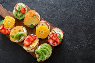 Meyve tatlı sandviç ya da bruschetta ricotta peynirli. Lezzetli sağlıklı kahvaltı tost ile krem peynir, organik meyve ve çilek, otlar, fındık ve arı polen. Diyet sağlıklı yemek, Kahvaltı, snack.