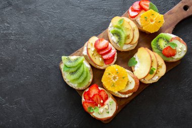 Ricotta peynirli meyve tatlı sandviç. Lezzetli sağlıklı kahvaltı tost ile krem peynir, taze organik meyve ve çilek, otlar, fındık ve arı polen. Diyet sağlıklı yemek, Kahvaltı, snack.