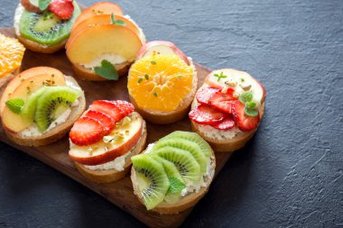 Meyve tatlı sandviç ya da bruschetta ricotta peynirli. Lezzetli sağlıklı kahvaltı tost ile krem peynir, organik meyve ve çilek, otlar, fındık ve arı polen. Diyet sağlıklı yemek, Kahvaltı, snack.