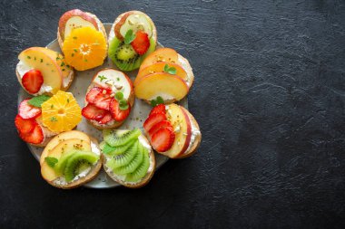 Ricotta peynirli meyve tatlı sandviç. Lezzetli sağlıklı kahvaltı tost ile krem peynir, taze organik meyve ve çilek, otlar, fındık ve arı polen. Diyet sağlıklı yemek, Kahvaltı, snack.