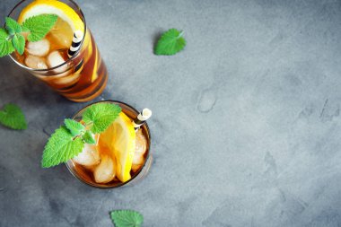 Buzlu çay limon, nane ve buz küpleri üzerinden kopya alanı gri beton arka plan ile. Buzlu soğuk yaz içeceği.