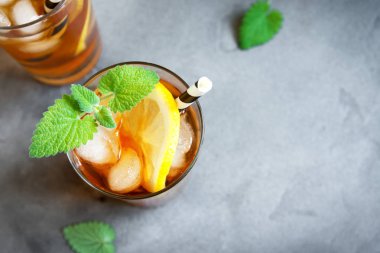 Buzlu çay limon, nane ve buz küpleri üzerinden kopya alanı gri beton arka plan ile. Buzlu soğuk yaz içeceği.