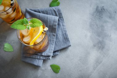 Buzlu çay limon, nane ve buz küpleri üzerinden kopya alanı gri beton arka plan ile. Buzlu soğuk yaz içeceği.