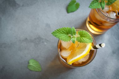 Buzlu çay limon, nane ve buz küpleri üzerinden kopya alanı gri beton arka plan ile. Buzlu soğuk yaz içeceği.