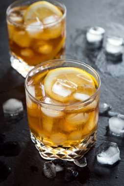 Siyah arka plan, limon ve buz küpleri ile viski yüksek kokteyl topu kopyalama alanı.