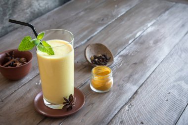 Zerdeçal Lassie veya lassi cam - sağlıklı probiyotik Hint soğuk içecek lor (yoğurt), süt, baharat ve şeker oluşur. Ahşap üzerinde zerdeçal güler yüzlü, kopya alanı.