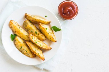 Patates dilimleri peynir ve ot ve beyaz tabakta - domates sosu ile pişmiş ev yapımı organik sebze vegan vejetaryen patates dilimleri aperatif yemek yemek.