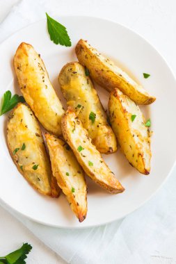 Patates dilimleri peynir ve ot ve beyaz tabakta - domates sosu ile pişmiş ev yapımı organik sebze vegan vejetaryen patates dilimleri aperatif yemek yemek.