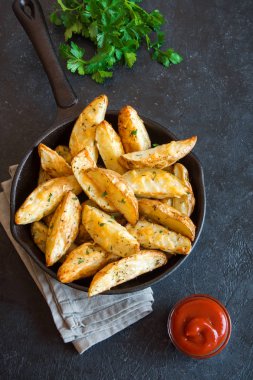 Patates dilimleri peynir ve ot ve siyah arka plan - üzerine domates sosu ile pişmiş ev yapımı organik sebze vegan vejetaryen patates dilimleri aperatif yemek yemek.