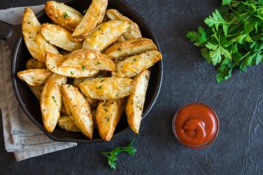 Patates dilimleri peynir ve ot ve siyah arka plan - üzerine domates sosu ile pişmiş ev yapımı organik sebze vegan vejetaryen patates dilimleri Aperatif yiyecek.