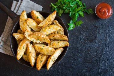 Patates dilimleri peynir ve ot ve siyah arka plan - üzerine domates sosu ile pişmiş ev yapımı organik sebze vegan vejetaryen patates dilimleri Aperatif yiyecek.