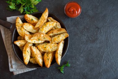 Patates dilimleri peynir ve ot ve siyah arka plan - üzerine domates sosu ile pişmiş ev yapımı organik sebze vegan vejetaryen patates dilimleri aperatif yemek yemek.