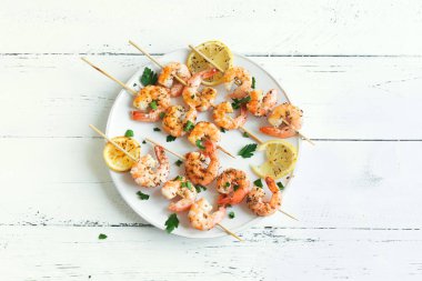 Izgara Karides Şiş şifreli. Deniz ürünleri, shelfish. Karides karides şiş Beyaz ahşap zemin, kopya alanı üzerine taze otlar ve baharatlar ile. Karides karides brochette kebap. Barbekü srimps karides.