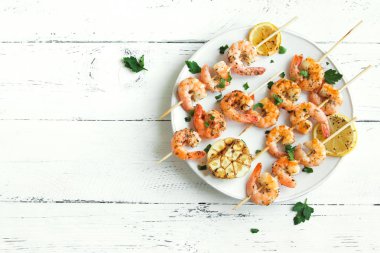 Izgara Karides Şiş şifreli. Deniz ürünleri, shelfish. Karides karides şiş Beyaz ahşap zemin, kopya alanı üzerine taze otlar ve baharatlar ile. Karides karides brochette kebap. Barbekü srimps karides.