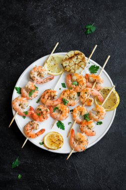 Izgara Karides Şiş şifreli. Deniz ürünleri, shelfish. Karides karides şiş taş siyah arka plan, kopya alanı üzerine taze otlar ve baharatlar ile. Karides karides brochette kebap. Barbekü srimps karides.