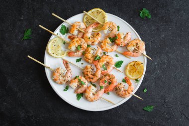 Izgara Karides Şiş şifreli. Deniz ürünleri, shelfish. Karides karides şiş taş siyah arka plan, kopya alanı üzerine taze otlar ve baharatlar ile. Karides karides brochette kebap. Barbekü srimps karides.