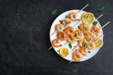Izgara Karides Şiş şifreli. Deniz ürünleri, shelfish. Karides karides şiş taş siyah arka plan, kopya alanı üzerine taze otlar ve baharatlar ile. Karides karides brochette kebap. Barbekü srimps karides.