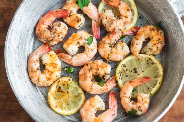 Limon, sarımsak ve otlar ile Kızarmış karides. Deniz ürünleri, shelfish. Baharat, sarımsak ve limon siyah taş zemin, kopya alanı üzerine karides karides ızgara. Karides karides Pan.