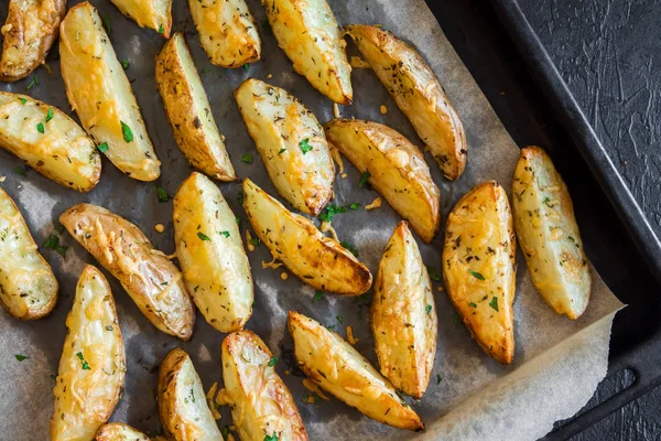 Patates dilimleri ile baharat, peynir ve fırın tepsisindeki - otlar pişmiş ev yapımı organik sebze vegan vejetaryen snack gıda.