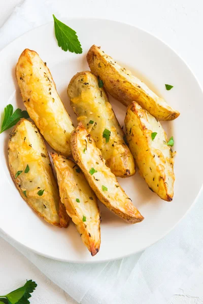 Patates dilimleri peynir ve ot ve beyaz tabakta - domates sosu ile pişmiş ev yapımı organik sebze vegan vejetaryen patates dilimleri aperatif yemek yemek.