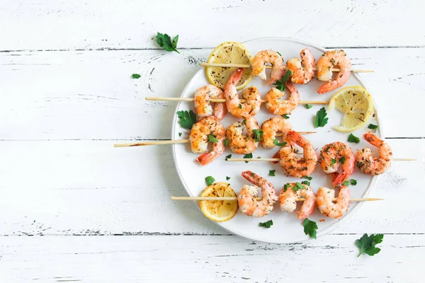 Izgara Karides Şiş şifreli. Deniz ürünleri, shelfish. Karides karides şiş Beyaz ahşap zemin, kopya alanı üzerine taze otlar ve baharatlar ile. Karides karides brochette kebap. Barbekü srimps karides.