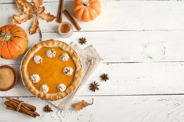 Kabak pasta krema ve tarçın Beyaz ahşap zemin üzerinde üst görünüm. Şükran günü geleneksel Pumpkin Pie için ev yapımı hamur işleri.