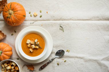Balkabağı çorbası ve organik kabaklar, üstten görünüm. Mevsim sonbahar gıda - baharatlı balkabağı çorbası kruton ile.