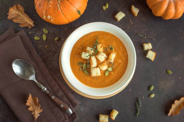 Balkabağı çorbası ve organik kabaklar, üstten görünüm. Mevsim sonbahar gıda - baharatlı balkabağı çorbası kruton ile.
