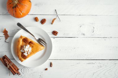 Beyaz ahşap zemin, üstten görünüm, üzerine Tarçın krem şanti, pekan somun ile kabak pasta alanı kopyalayın. Şükran günü - kabak pasta parçası için ev yapımı sonbahar pasta.