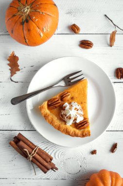 Beyaz ahşap zemin, üstten görünüm, üzerine Tarçın krem şanti, pekan somun ile kabak pasta alanı kopyalayın. Şükran günü - kabak pasta parçası için ev yapımı sonbahar pasta.