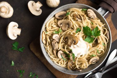 Mantar spagetti makarna ve krema sos rustik arka plan, üstten görünüm üzerinde. Pan pişirme champignon mantarlı ev yapımı makarna çeşitleri.