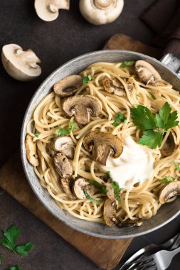 Mantar spagetti makarna ve krema sos rustik arka planda, üstten görünüm alanı kopyalayın. Pan pişirme champignon mantarlı ev yapımı makarna çeşitleri.