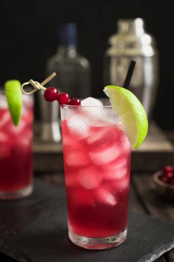 Cape Codder kokteyl kireç ve buz ile. Kızılcık ve votka alkol Cape Codder kokteyl koyu ahşap arka plan.