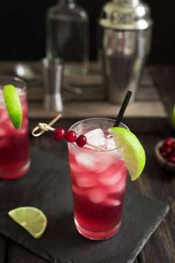 Cape Codder kokteyl kireç ve buz ile. Kızılcık ve votka alkol Cape Codder kokteyl koyu ahşap arka plan.