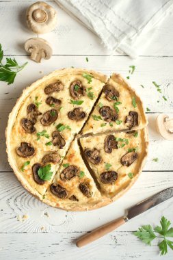 Mantarlı kiş pasta petrol ve peynir Beyaz ahşap arka planda, üstten görünüm. Mantar ile tuzlu tart.