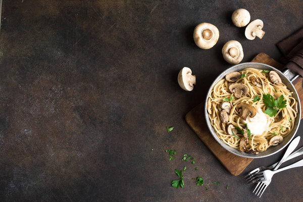 Грибы Паста-спагетти и сливочный соус на деревенском фоне, вид сверху, копировальное пространство. Домашняя итальянская макароны с шампиньоном гриб в кастрюлю
.