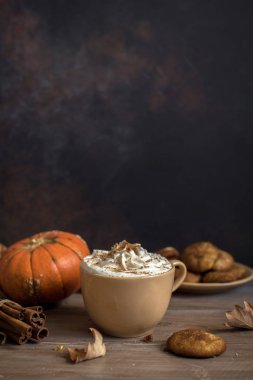 Kabak Spice Latte. Mevsim sonbahar baharatlar, kurabiye ve Sonbahar dekorasyonu ile Latte fincan. Kahve içmeye geleneksel sonbahar tatil.