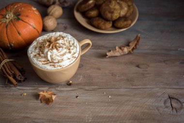 Kabak Spice Latte. Mevsim sonbahar baharatlar, kurabiye ve Sonbahar dekorasyonu ile Latte fincan. Kahve içmeye geleneksel sonbahar tatil.
