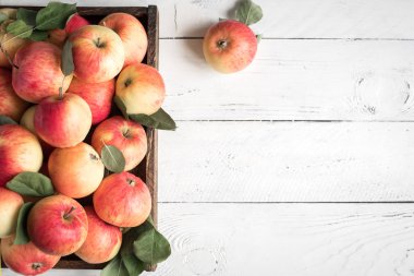 Ahşap kutusunda kırmızı elma. Beyaz ahşap arka plan, kopya alanı yapraklarda ile organik kırmızı elma.
