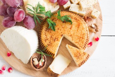 Peynir tabağı ile çeşitli peynirler, üzüm, fındık beyaz arka planda, kopya alanı. İtalyan peynir ve meyve tabağı.