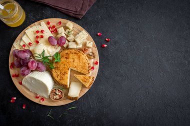 Peynir tabağı ile çeşitli peynirler, üzüm, fındık siyah arka plan, kopya alanı. İtalyan peynir ve meyve tabağı.