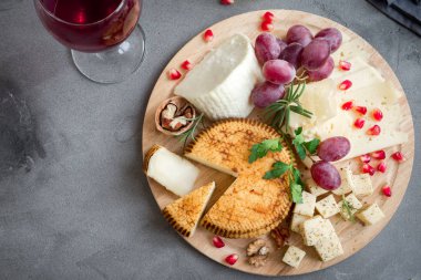 Peynir tabağı ile çeşitli peynirler, üzüm, fındık gri taş zemin, kopya alanı üzerinde. İtalyan peynir ve meyve tabağı.