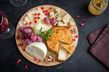 Peynir tabağı ile çeşitli peynirler, üzüm, fındık siyah arka plan, kopya alanı. İtalyan peynir ve meyve tabağı.