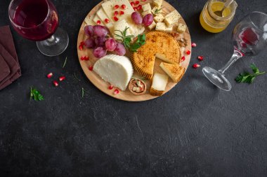 Peynir tabağı ile çeşitli peynirler, üzüm, fındık siyah arka plan, kopya alanı. İtalyan peynir ve meyve tabağı.