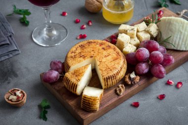 Peynir tabağı ile çeşitli peynirler, üzüm, fındık gri taş zemin, kopya alanı üzerinde. Meyve ve şarap ile İtalyan peynir ve meyve tabağı.