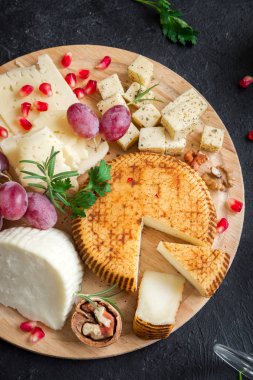 Peynir tabağı ile çeşitli peynirler, üzüm, fındık siyah arka plan, kopya alanı. İtalyan peynir ve meyve tabağı.