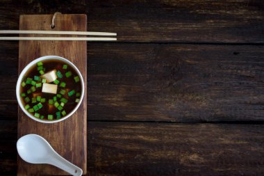 Japon miso çorbası koyu ahşap arka plan, kopya alanı üzerinde seramik kase. Asya miso çorbası ile tofu.