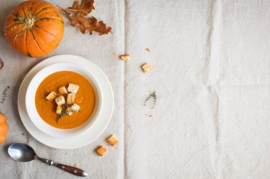 Balkabağı çorbası ve organik kabaklar, üstten görünüm. Mevsim sonbahar gıda - baharatlı balkabağı çorbası kruton ile.