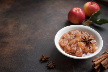 Ev yapımı elma reçel (elma Hint turşusu, marmelat, tıknaz sos) tarçın, anason ve elma rustik zemin üzerine kapatın. Geleneksel sonbahar elma reçel.