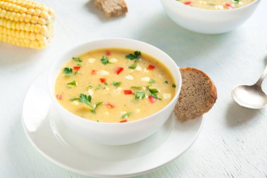 Ev yapımı Mısır çorbası çorba beyaz kase. Yeşiller ve sebze vejetaryen kremalı mısır çorbası.